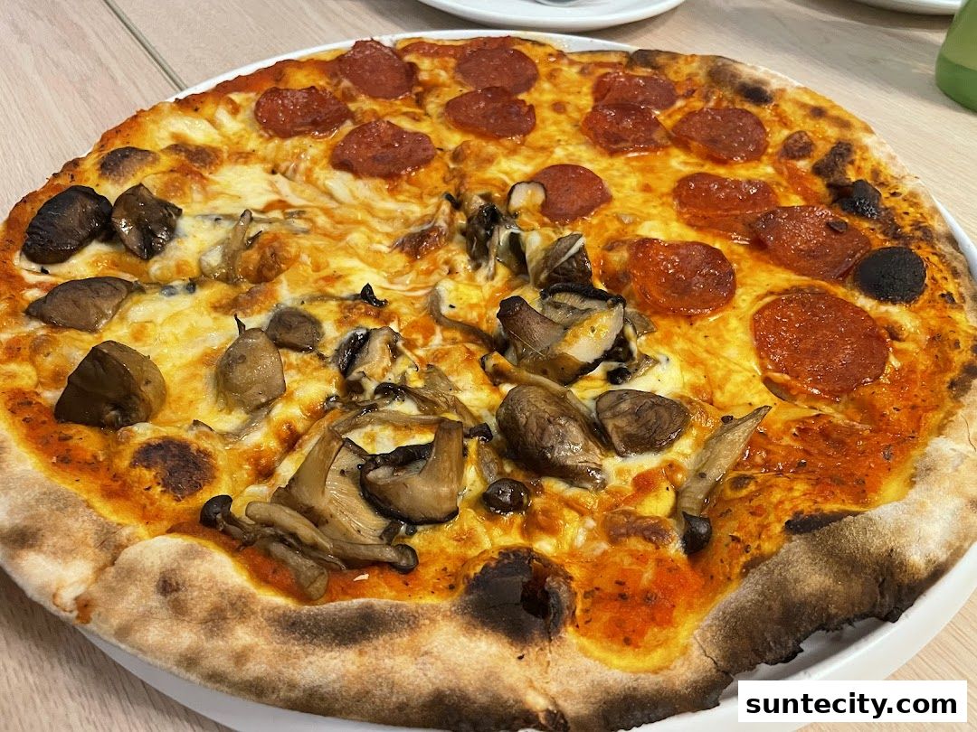 A delicious pepperoni and mushroom pizza with a golden crust on a white plate.