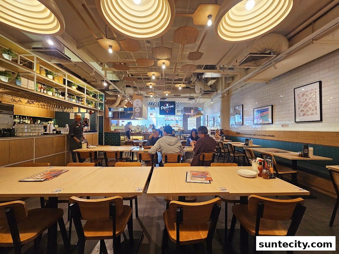 Interior view of Peperoni Pizzeria with tables, chairs, and a bar area.