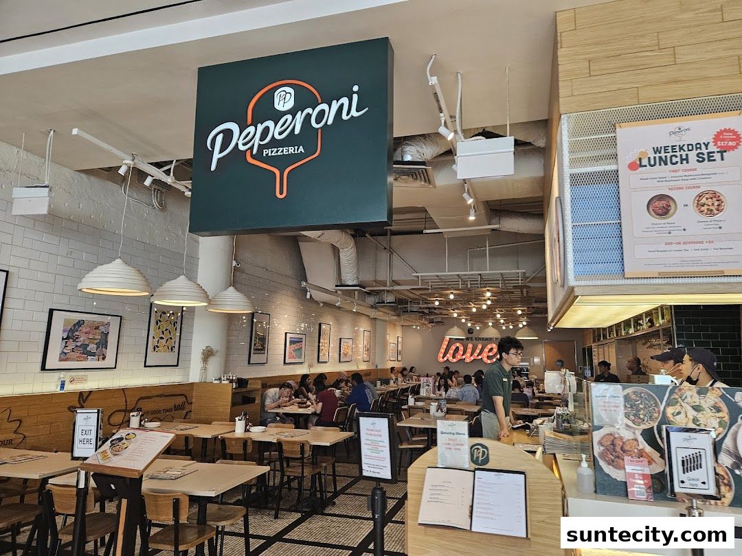 Interior view of Peperoni Pizzeria with tables, seating, and a counter.