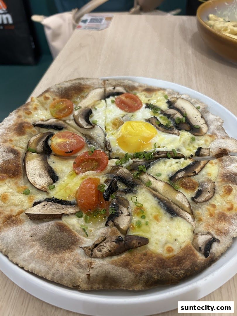 A delicious pizza topped with mushrooms, cherry tomatoes, and a fried egg.