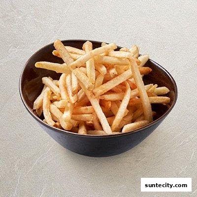 A dark bowl filled with golden French fries on a light-colored surface.