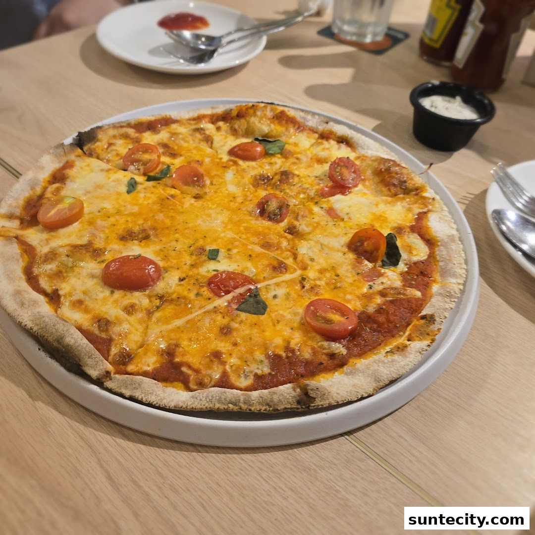A delicious pizza with cherry tomatoes and melted cheese on a wooden table.