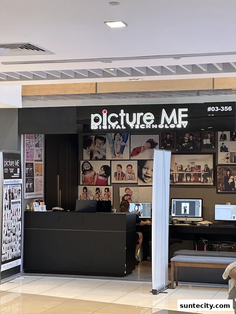 The Picture Me photography studio entrance with a reception desk and displayed portraits.