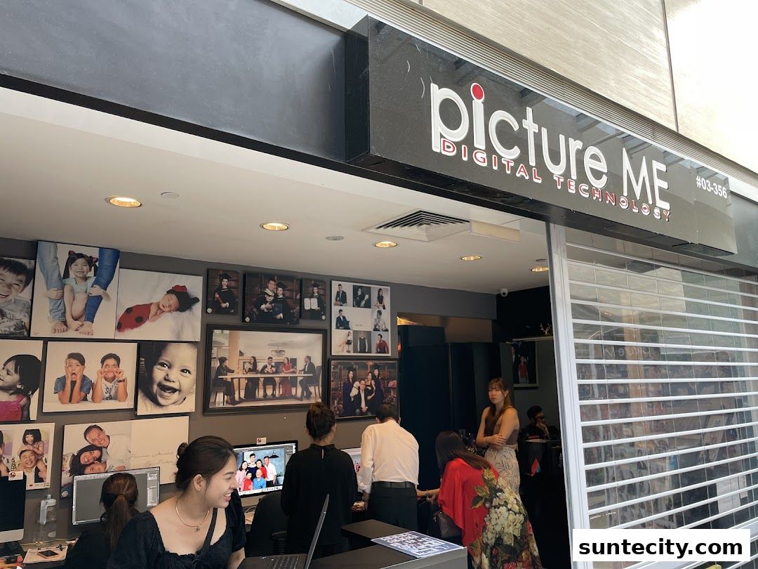 The entrance of a photography studio called Picture Me, displaying various family portraits.