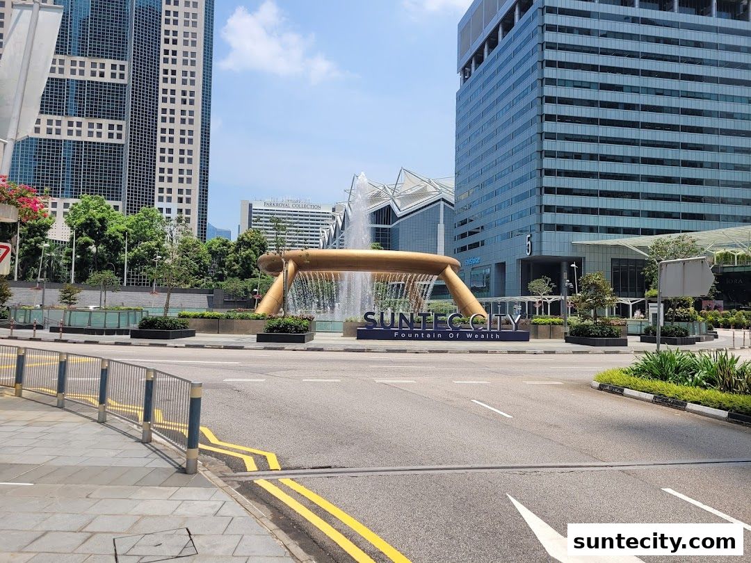 The Suntec City Fountain of Wealth with surrounding buildings and a street.