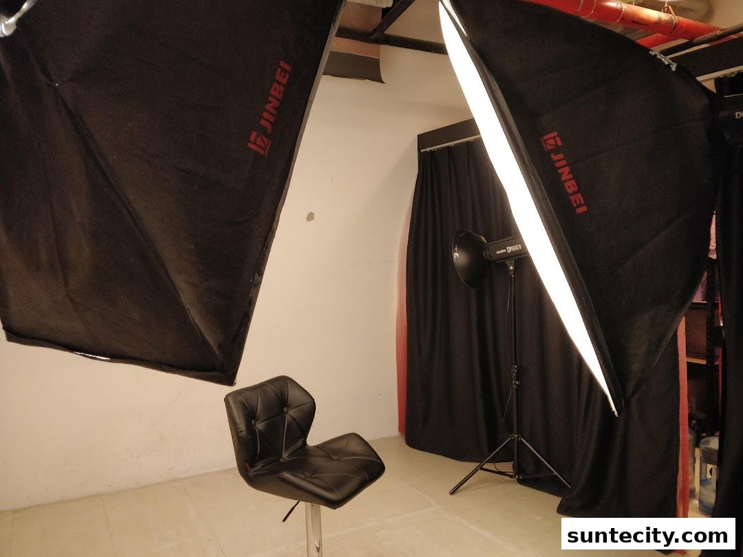 A photography studio setup with lighting equipment and a chair.