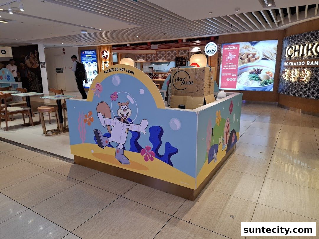A colorful kiosk with cartoon characters and a display of ramen in the background.