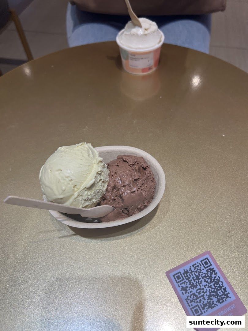 Two scoops of ice cream in a bowl with a QR code on the table.