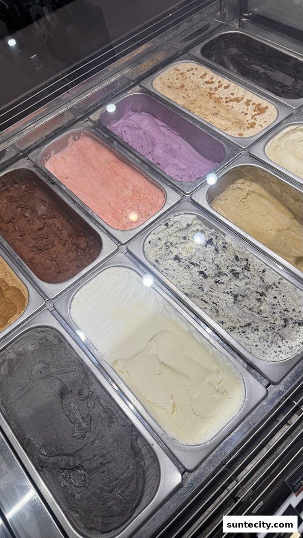 A display of various flavors of artisanal ice cream in metal containers.