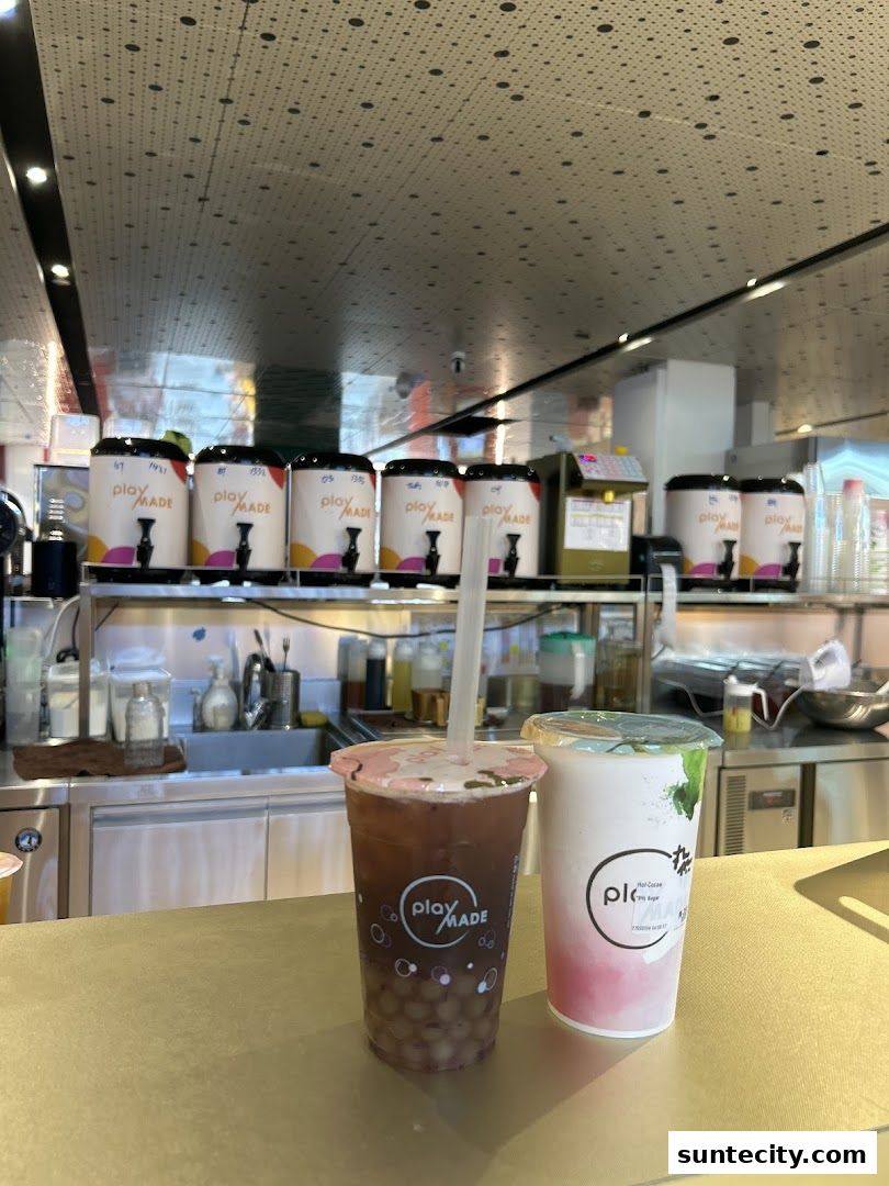Two bubble tea drinks with the 'Playground by PlayMade' logo are displayed on a counter.