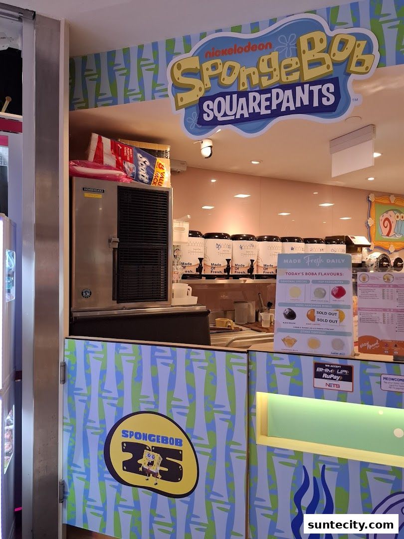 A Spongebob Squarepants themed boba tea shop counter with various flavors and payment options displayed.