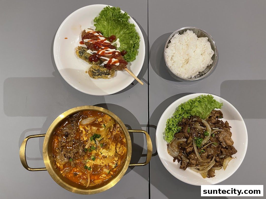 A top-down view of a table with various Korean street food dishes and rice.