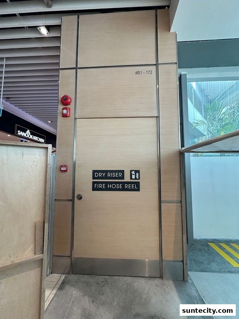 A closed door with 'DRY RISER' and 'FIRE HOSE REEL' labels, and a fire alarm.