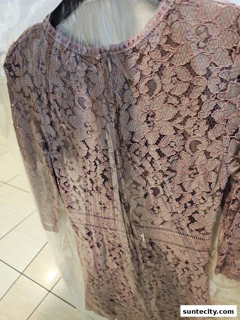 A close-up view of a delicate lace dress, professionally cleaned and ready for wear.