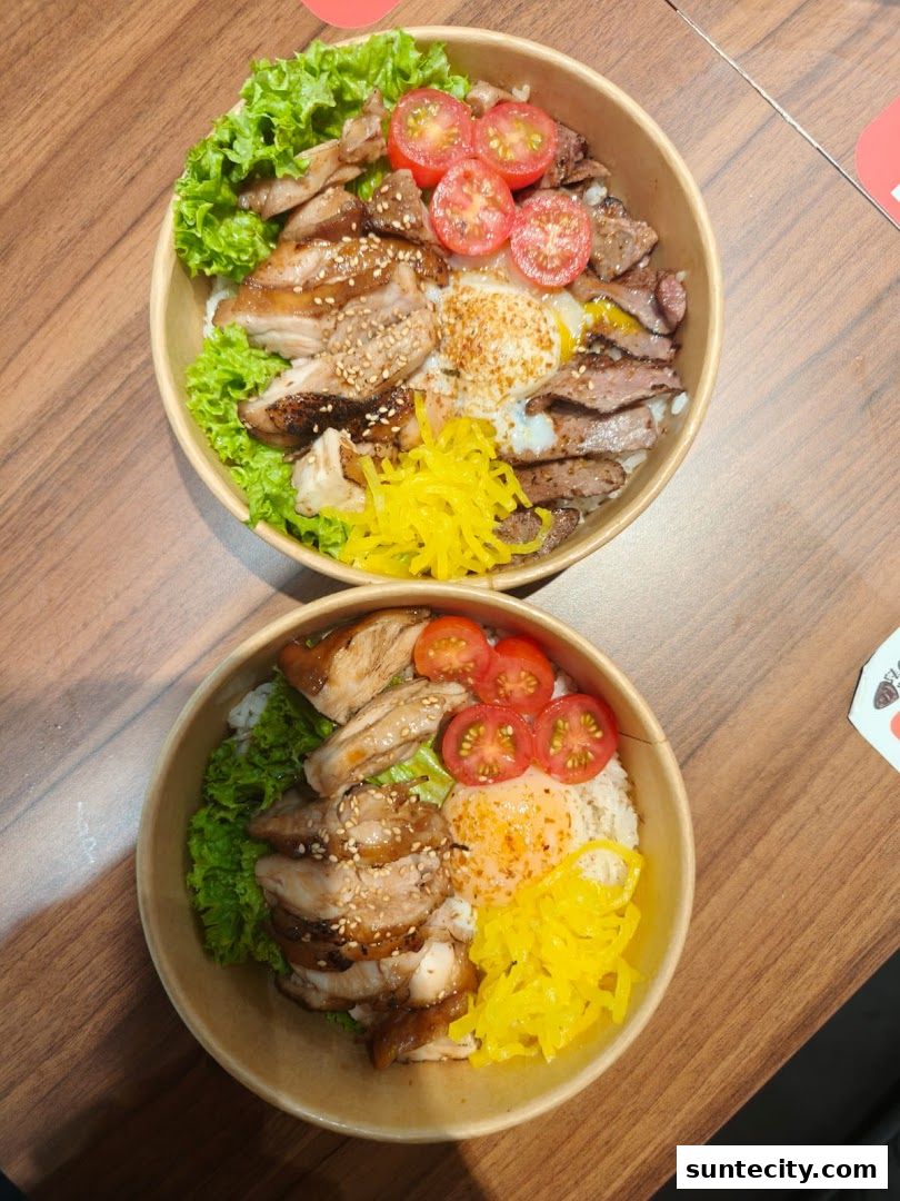 Two bowls of rice topped with grilled chicken, beef, egg, lettuce, tomatoes, and pickled ginger.