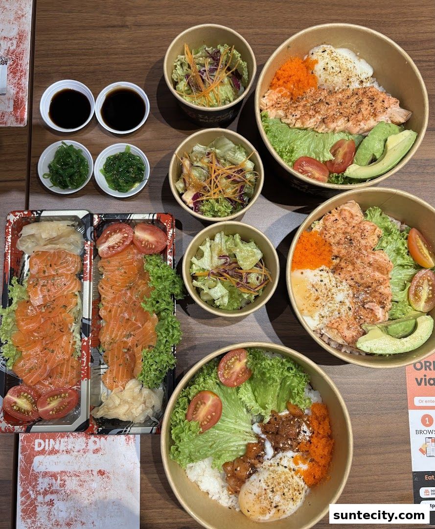A spread of salmon dishes, including sashimi and rice bowls, with side salads and sauces.