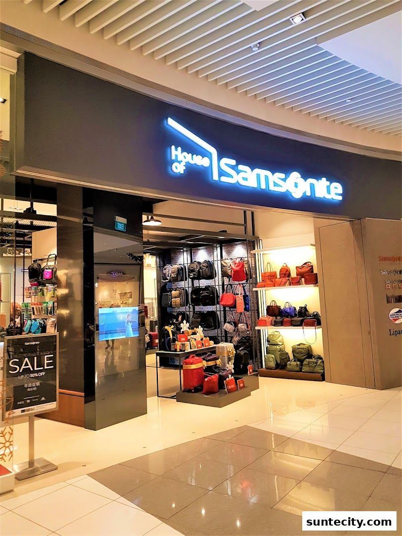The entrance of a Samsonite store showcasing various bags and a sale sign.