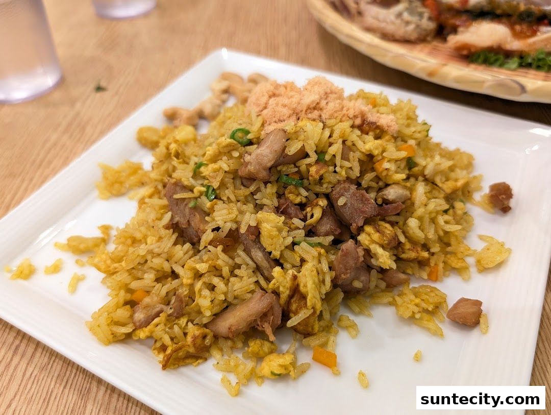 A plate of savory fried rice with meat and shredded pork topping.
