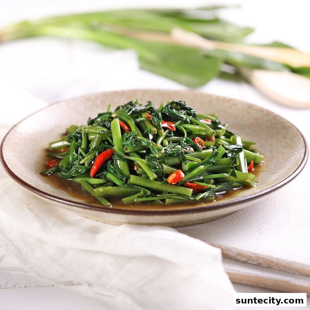 A plate of stir-fried water spinach with chili peppers and a savory sauce.