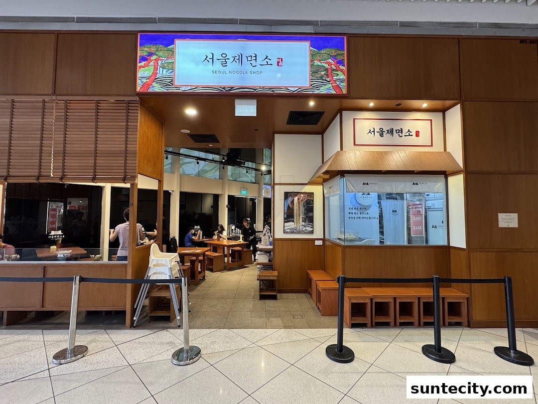 The exterior of Seoul Noodle Shop with seating and a prominent sign.
