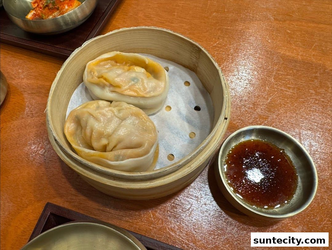Steamed dumplings served in a bamboo steamer with a side of dipping sauce.