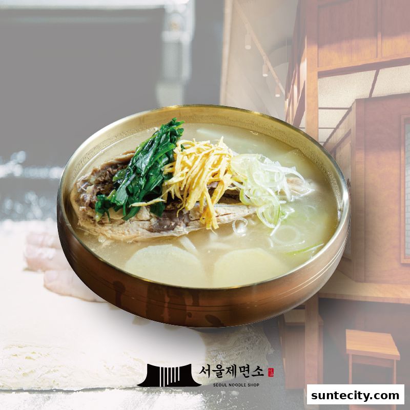 A steaming bowl of Korean noodle soup with meat, vegetables, and egg garnish.