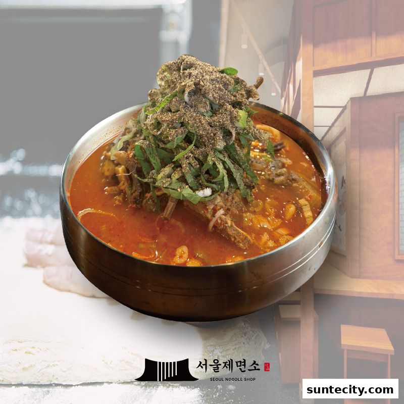 A steaming bowl of Korean noodle soup with generous toppings and the shop's logo.