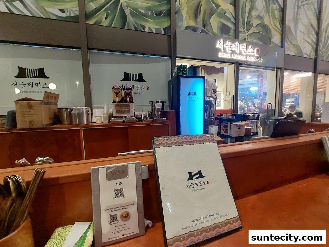 A view of the Seoul Noodle Shop counter with a menu and payment terminal.