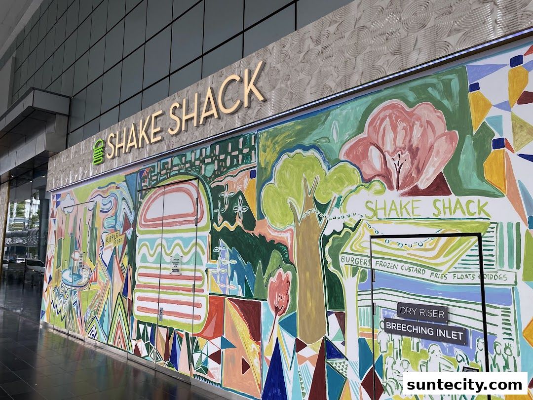 The exterior of Shake Shack Suntec featuring a vibrant, colorful mural and the restaurant's signage.