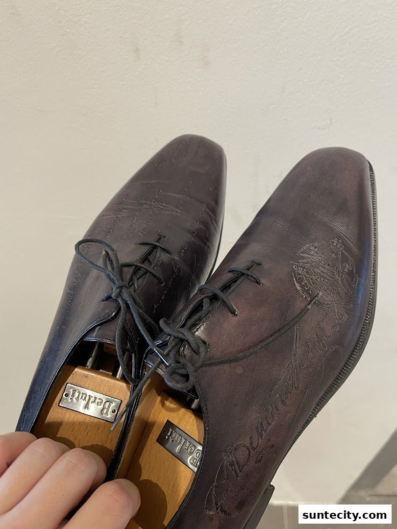Close-up of elegant men's dress shoes with intricate detailing and shoe trees.