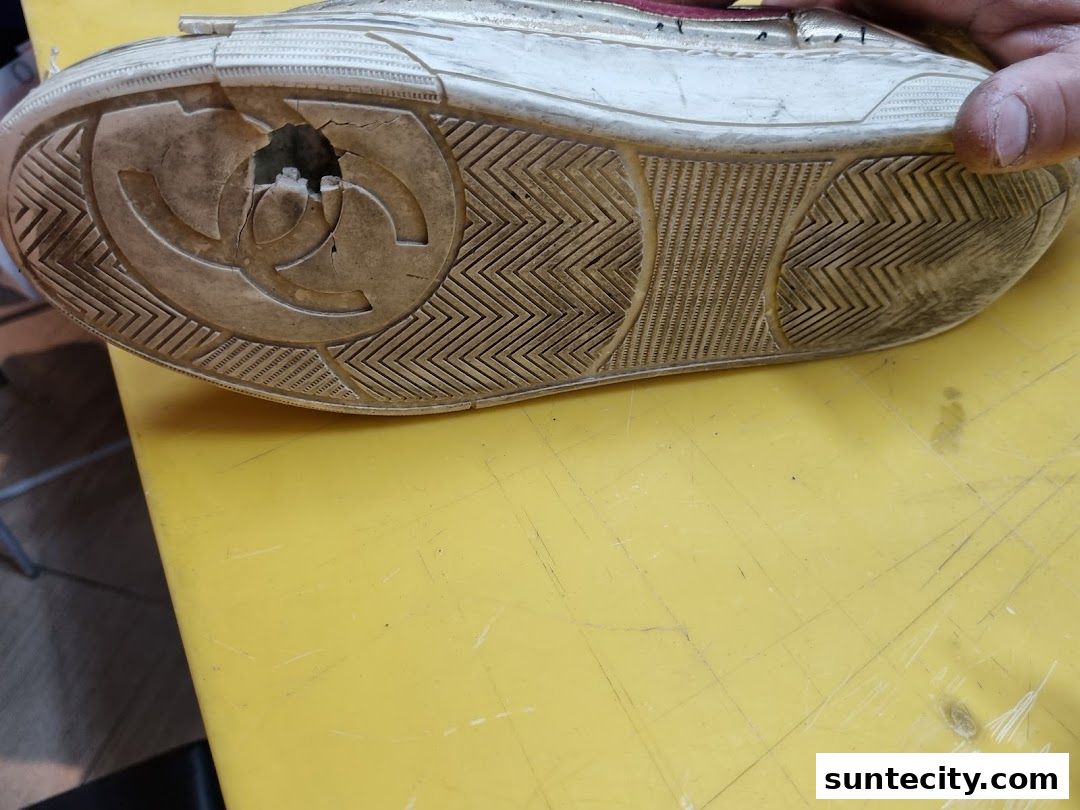 A close-up shot of a damaged shoe sole with a hole in the center.