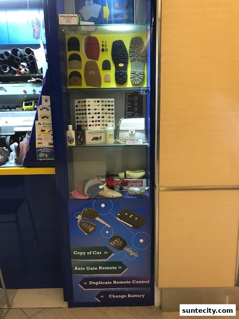 A display cabinet showcasing shoe repair items, car keys, and accessories.