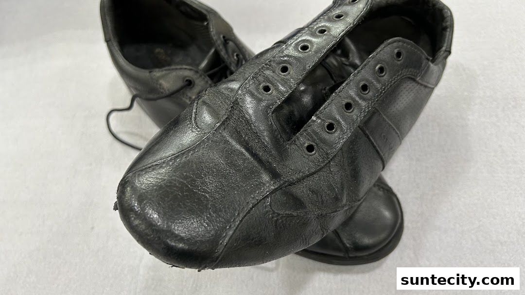 A close-up shot of a pair of black leather shoes without laces.