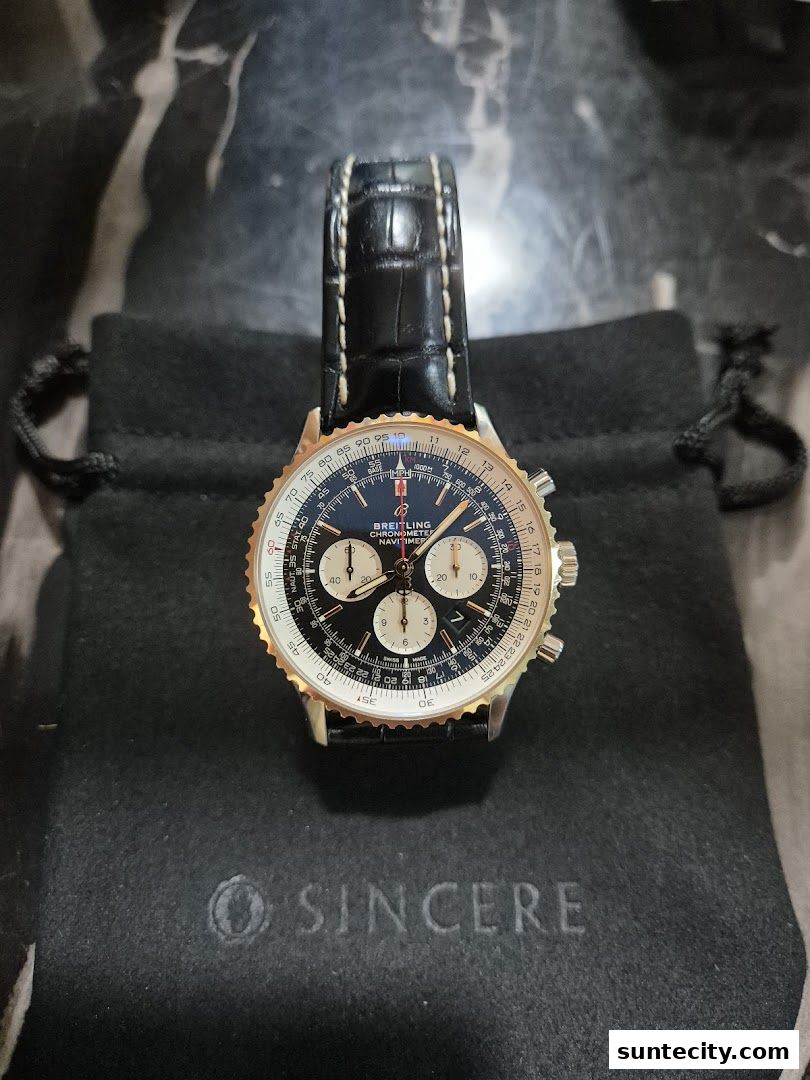 A Breitling Navitimer watch with a black leather strap on a black pouch with the Sincere logo.