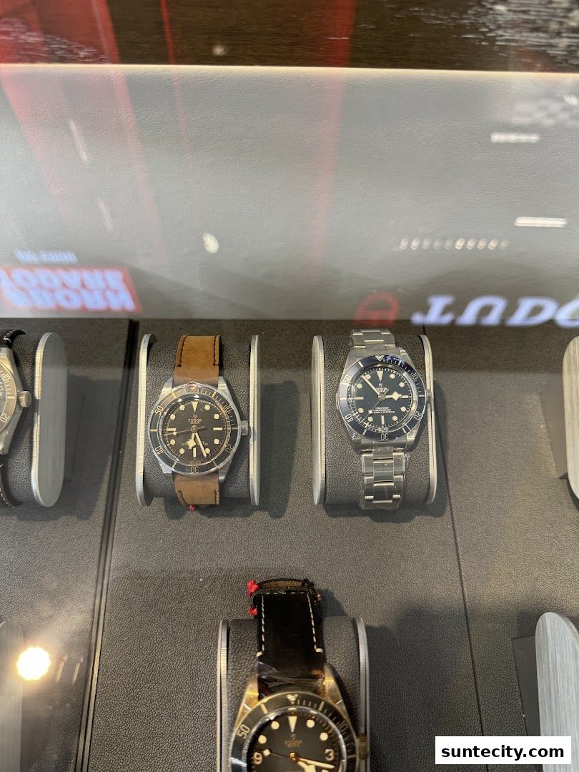 A display case showcasing several luxury watches with leather and metal straps.