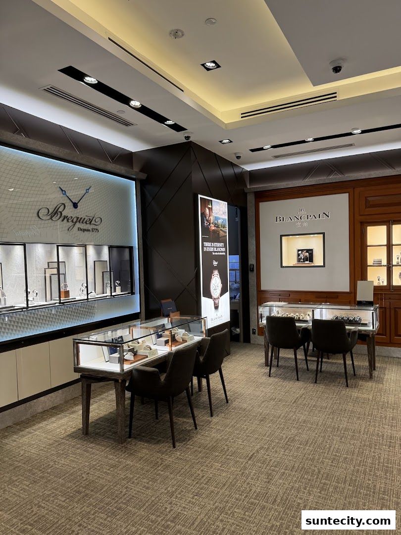 Interior view of a luxury watch store showcasing display cases with watches and brand signage.
