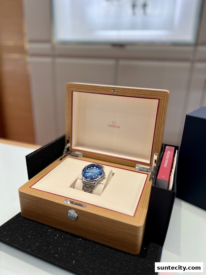 An Omega watch displayed in its wooden presentation box with operating instructions.