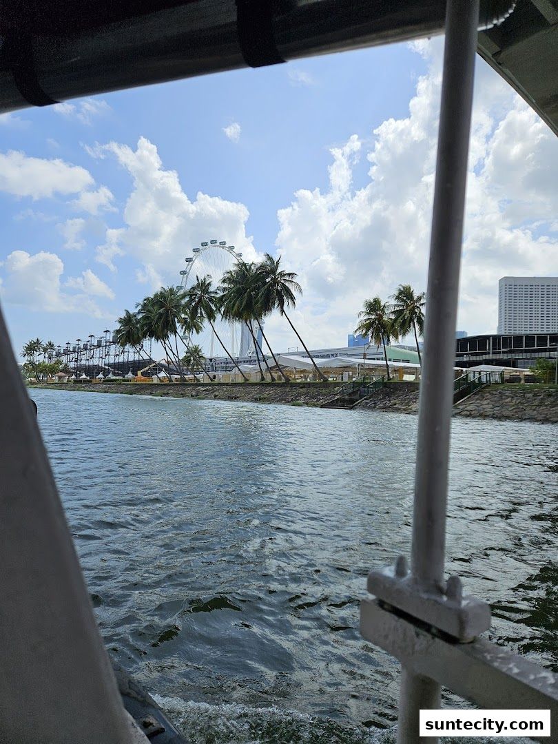 View of Singapore Flyer and Marina Bay from a boat on a sunny day.