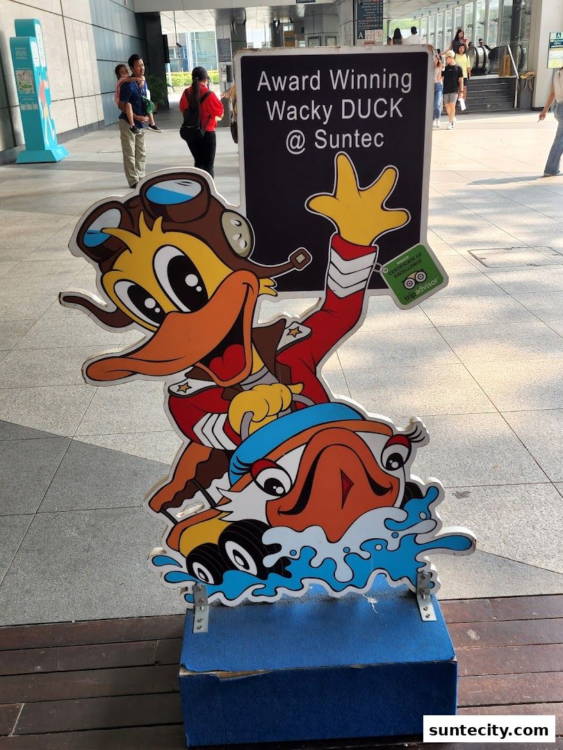 A cutout of a cartoon duck in a pilot outfit with a sign advertising 'Award Winning Wacky DUCK @ Suntec'.
