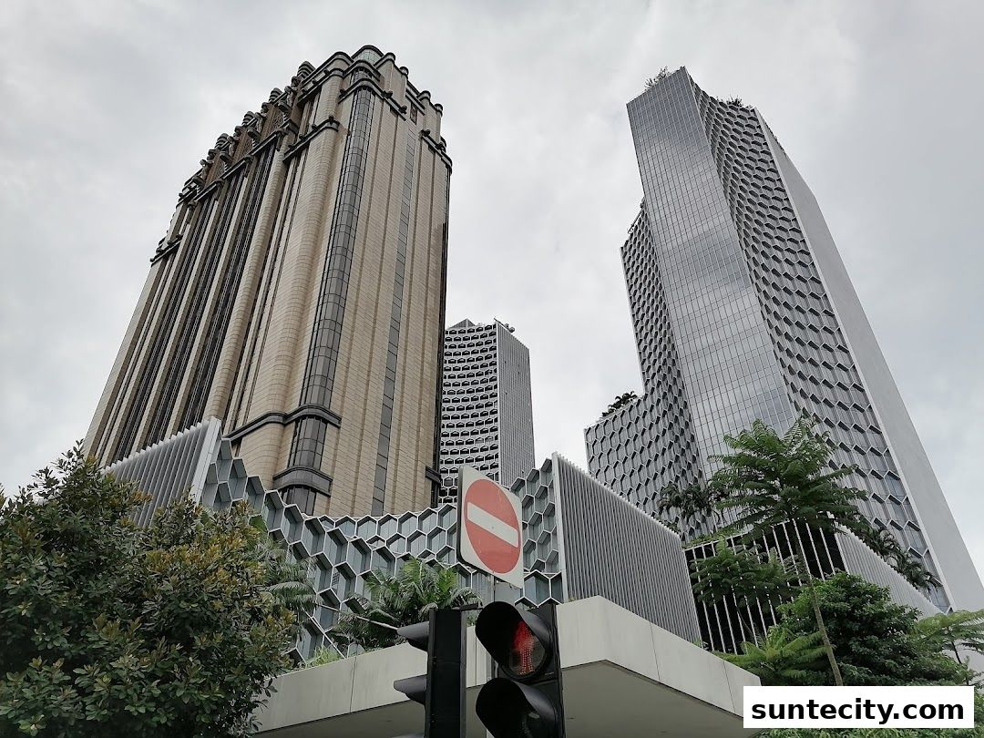 Modern skyscrapers with unique honeycomb facade and lush greenery.