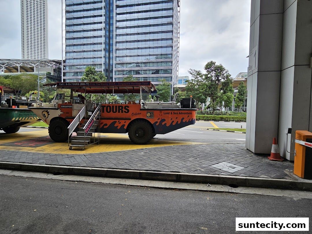 A Singapore DUCKtours amphibious vehicle parked on a street with modern buildings in the background.