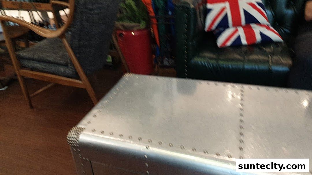 Interior shot of a shop with a wooden chair, a red pot, and a leather sofa with Union Jack pillows.