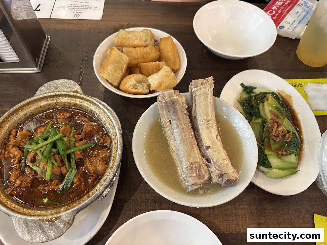 A table laden with delicious Song Fa Bak Kut Teh dishes, including pork ribs and fried dough sticks.