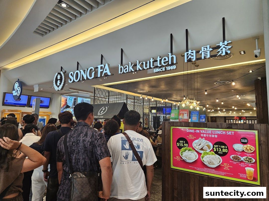 A crowd of people queuing outside Song Fa Bak Kut Teh, with a prominent sign and lunch set promotion.