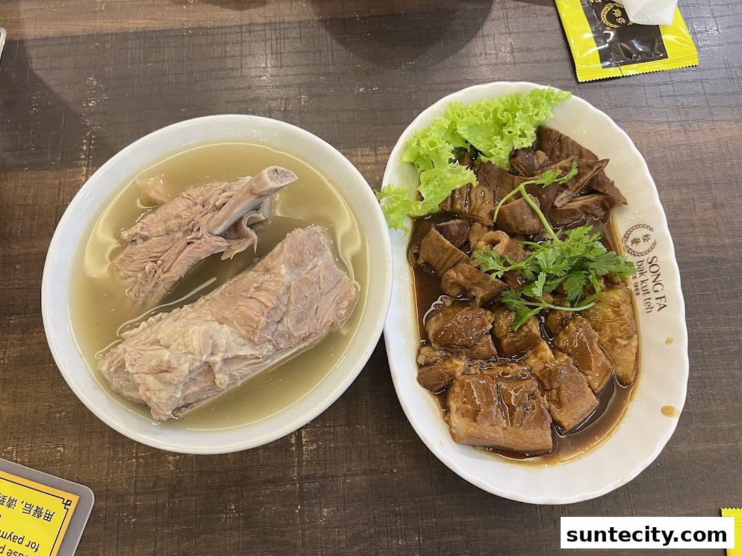A close-up of two bowls of food, one with pork ribs in broth and the other with braised pork belly and intestines.