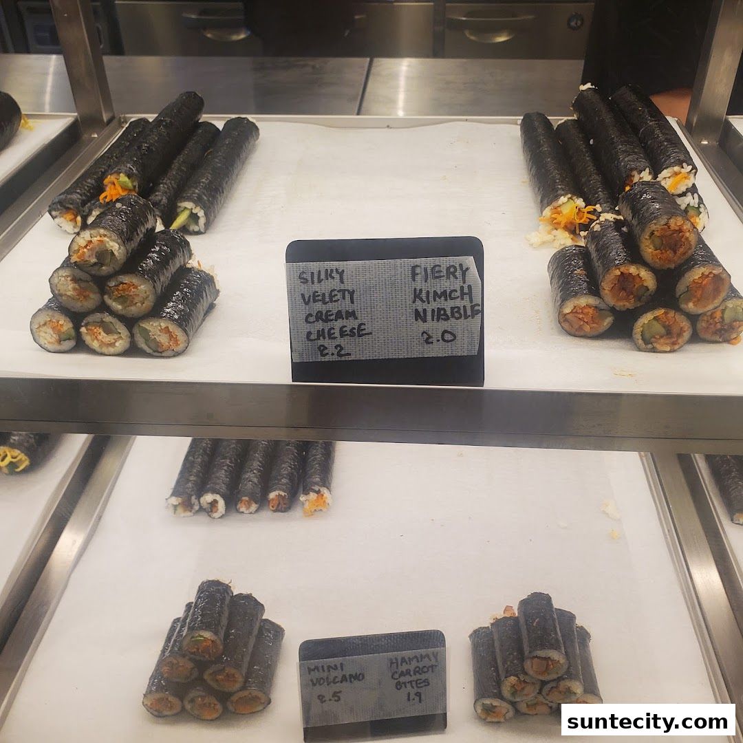 A display case filled with various types of sushi rolls and Korean gimbap.