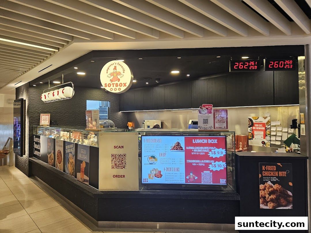 A view of the SOTBOX Korean food stall with a display of menu items and a digital price board.
