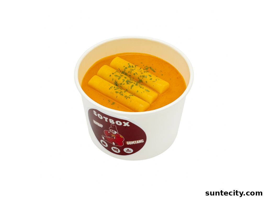 A white cup filled with a creamy orange sauce and topped with three cylindrical pieces of food and parsley.