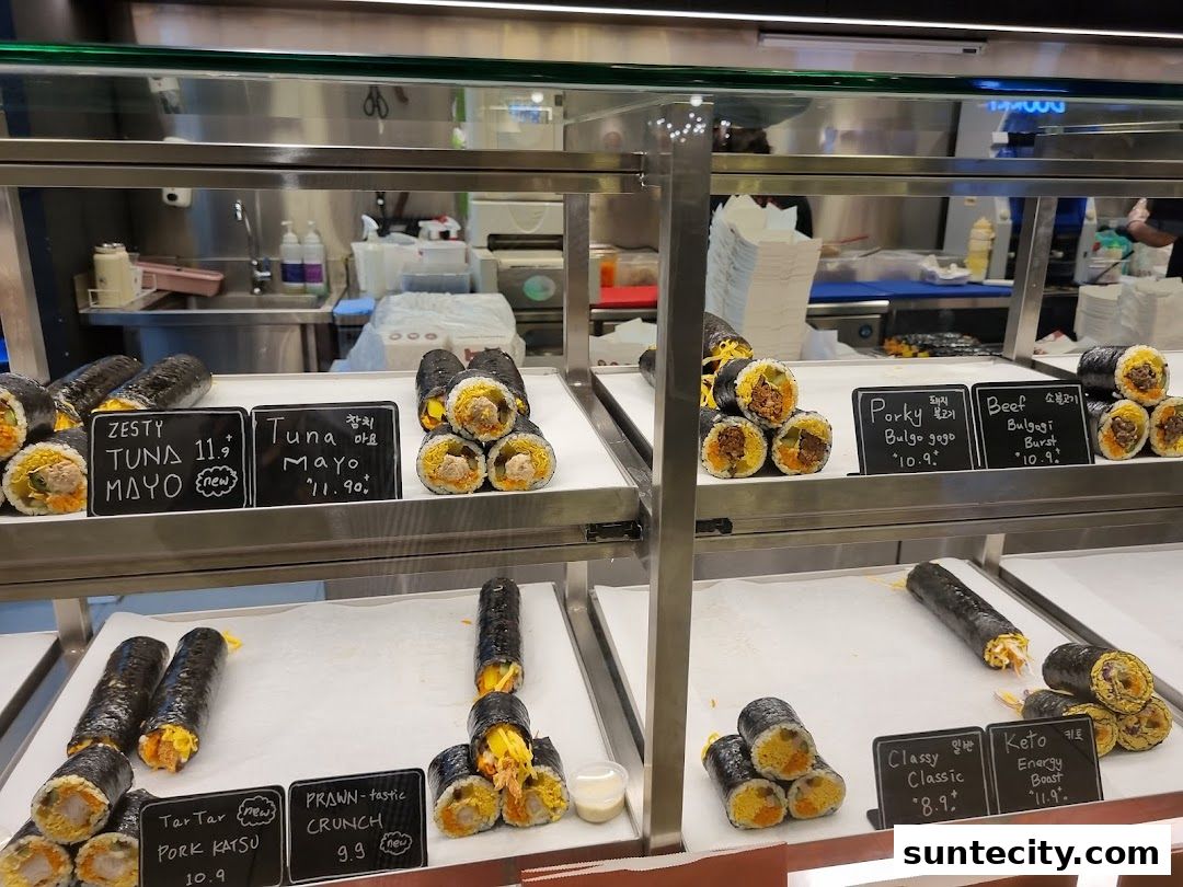 A display of various Korean kimbap rolls with different fillings and labels.