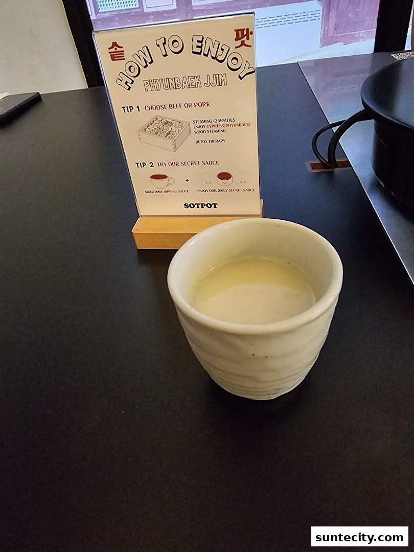 A sign explains how to enjoy Phyubaek Jjim at SOTPOT, with a drink in a cup.